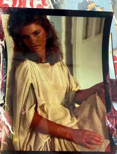 A knitted sweater and a white clapboard wall. The print is worn through at the edges.