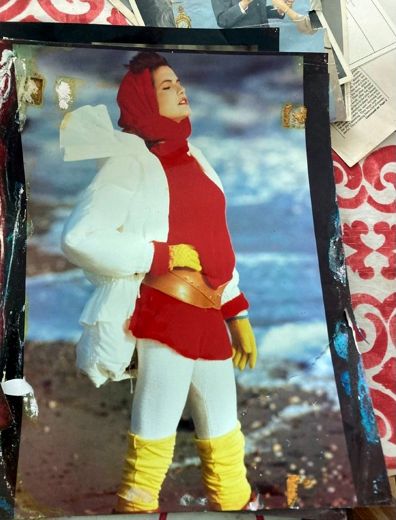 Red hood, white jacket, yellow leg-warmers, at the edge of the bay.