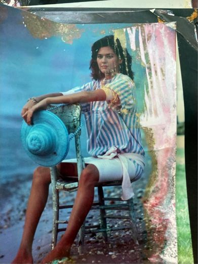 Striped dress and a straw hat with a blue ribbon, on a chair at the water.